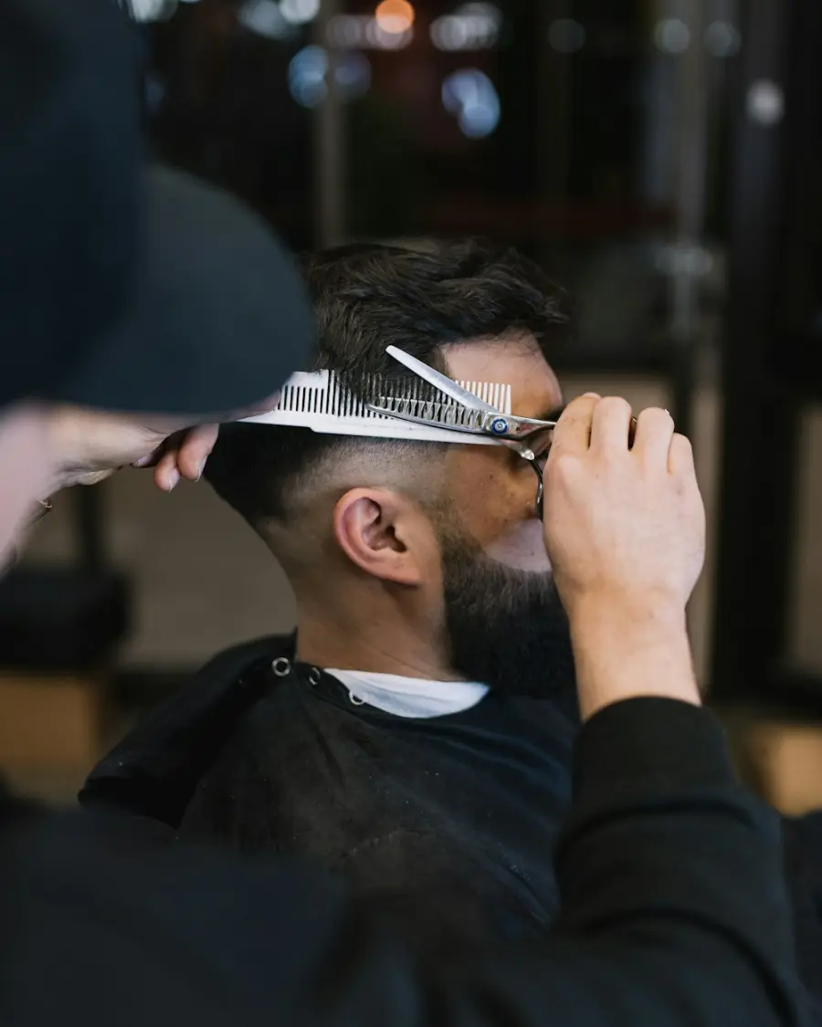 Um barbeiro cortando o cabelo de um cliente com tesoura